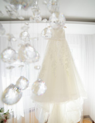 Look through the crystals hanging from chandelier at white dress
