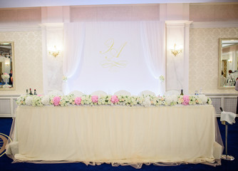 White table with garland of pink and white roses stands on blue