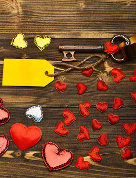 valentines red heart, tag, gold ribbon and key on wood