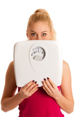 Worried woman standing on scale measuring weight