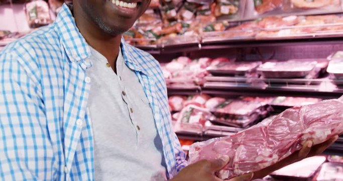 Couple buying beef at grocery section