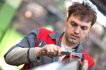 Factory Man Worker Measuring Detail with Vernier Caliper at Workshop