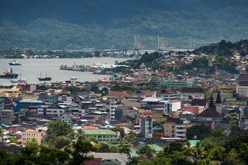 Ambon City, Indonesia. Ambon City on Ambon Island boasts excellent transport connections and facilities and make it a gateway to Maluku, and its colonial forts, green hills and pleasant beaches.