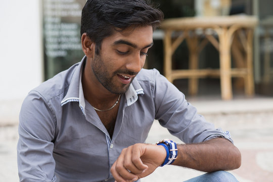 Closeup portrait handsome man looking to his wristwatch frustrated that his girl friend partner client is late to the date meeting