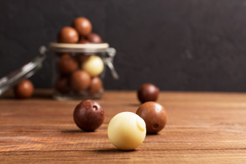 Chocolate candies on a wooden background, bank, horizontal, selective focus