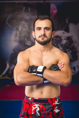 Mixed martial arts fighter standing with his arms crossed in a close up shot facing camera