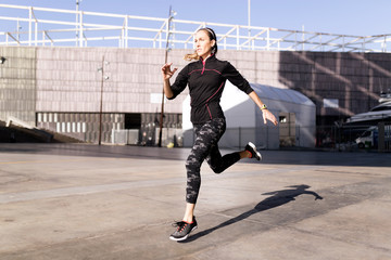 Fototapeta na wymiar Beautiful young woman running in urban environment.