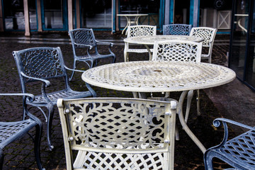 Empty metal tables and chairs in a street cafe in the fall.