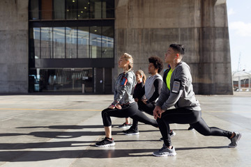 Obraz premium Portrait of running people doing stretching in the city.