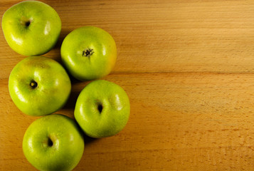 Fresh green apples on wooden background