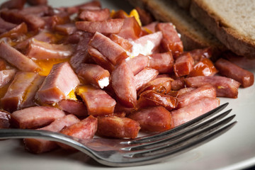 Pieces of sausage fried with egg.