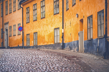 Fototapeta na wymiar Old parts of Stockhom with cobblestones and orange old facades