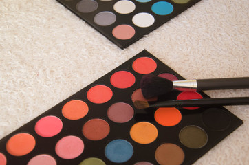 Colorful eyeshadow palette and make-up brushes, close-up.