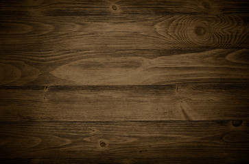 Old weathered wood surface with long boards lined up. Wooden planks on a wall or floor with grain and texture. Dark neutral tones with contrast.