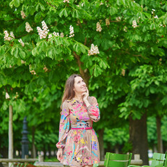 Young woman in the Tuileries garden, walking under chestnut trees in full bloom
