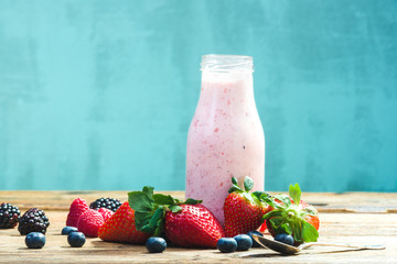 Bottles of fruits yogurt with fresh fruits.