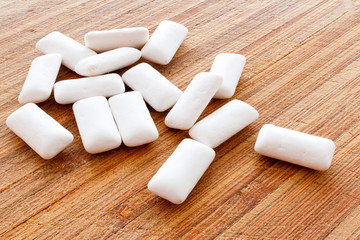 Chewing gum pieces on a wooden background