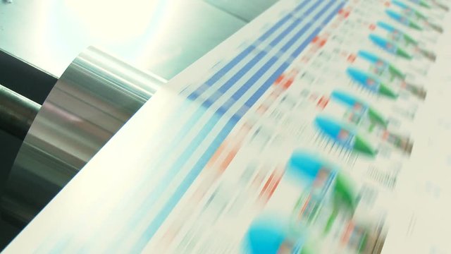 Crane shot of offset printing press working at high speed printing paper products