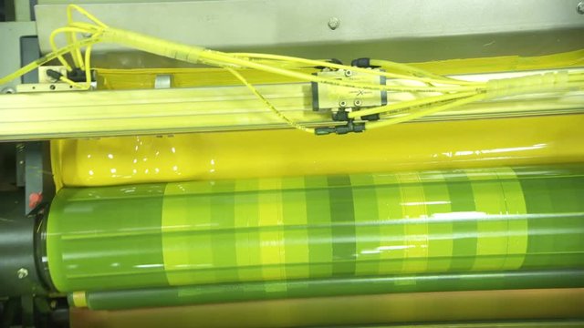 Crane shot of offset printing press working at high speed printing paper products
