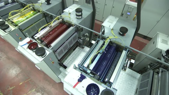 Crane shot of offset printing press working at high speed printing paper products