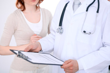 Close up of a male doctor holding an application form while consulting patient