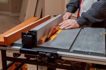 Circular saw cutting wooden plank close-up blade