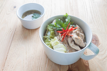 steamed chicken breast.White cup on a plate placed on a wooden t