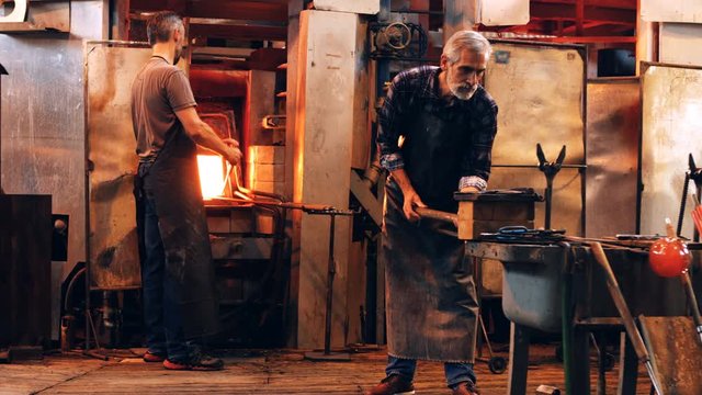 Glassblower shaping a molten glass