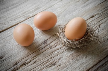 Chicken eggs on old wooden table background