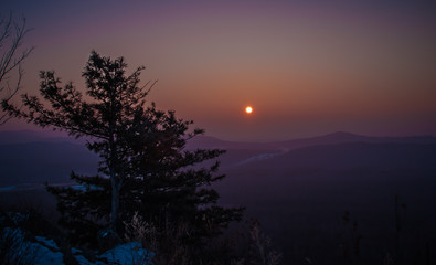 Fototapeta na wymiar Sunrise in the mountains in winter with long cedar