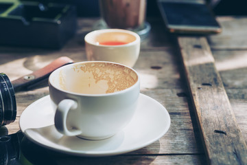 Old coffee cup and leather key chain and ashtray on vintage wood table