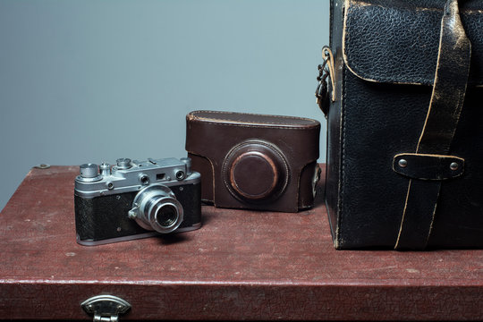 Camera and carrying case on old suitcase