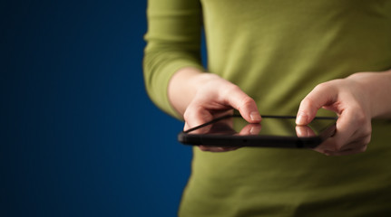 Fototapeta premium Close up of hand holding digital touchpad tablet device