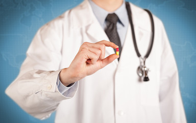 Doctor in white holding a pill