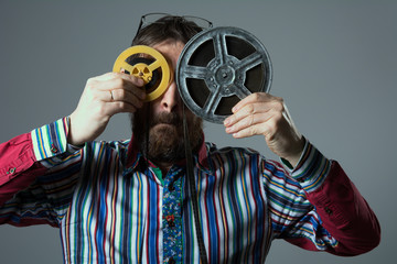 Obraz premium Bearded man with two 16mm film reel