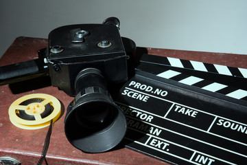 Old movie camera clapper and reel with a film