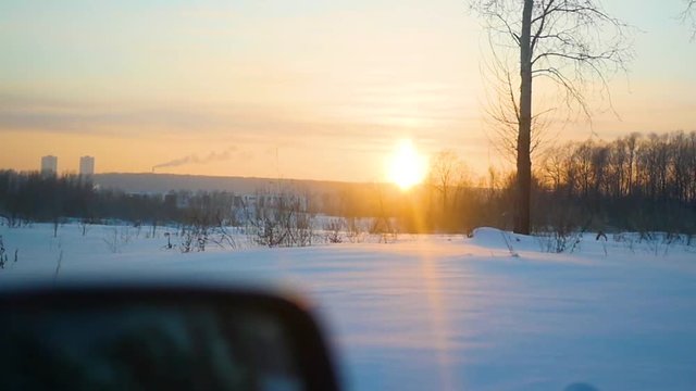 The car rides on winter road at sunset. Point of view