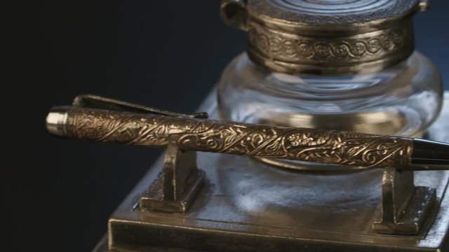 Antique pen on dark reflective surface