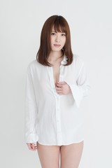 白いシャツを着たセクシーな女性。この女性は、脚の素肌を見せています。スタジオ撮影。白背景。