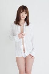 白いシャツを着たセクシーな女性。この女性は、脚の素肌を見せています。スタジオ撮影。白背景。