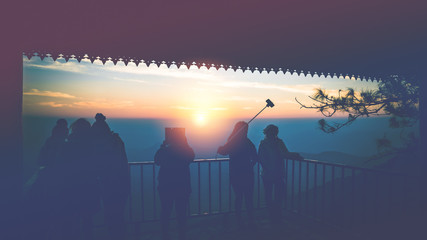 Tourists photograph the sunrise in the morning on the mountain.