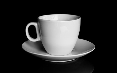 white cup and white saucer with reflection isolated on black bac