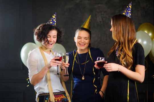 Three young women celebrate someone's birthday.