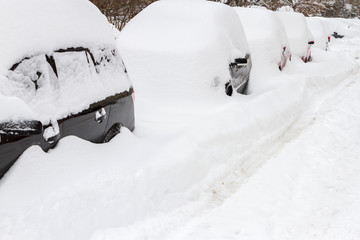 Car covered with snow in the parking after a snow storm