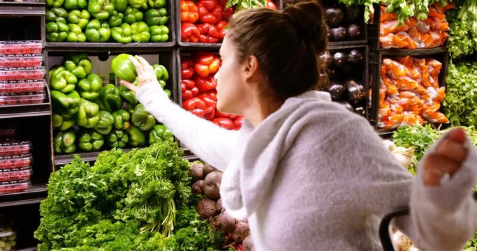 Woman buying capsicum in organic section