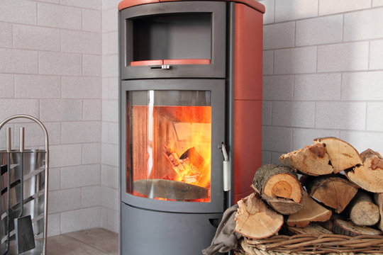 Kamin mit Holz im Weidekorb