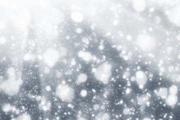 Obraz premium Snowflakes particles and white bokeh or glitter lights on silver background. Christmas abstract template