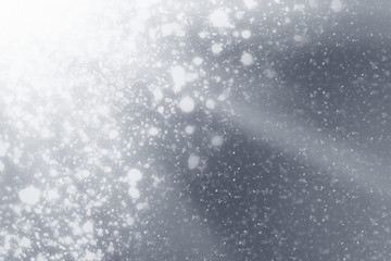 Snowflakes rays and bokeh or glitter lights on silver background. Christmas abstract template