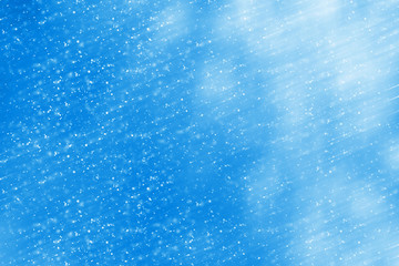 Abstract round silver bokeh or glitter lights on blue background. Circles defocused particles and rays