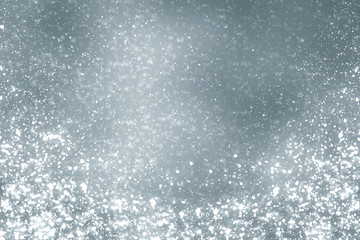 Snowflakes particles and bokeh or glitter lights on silver background .Festive abstract template